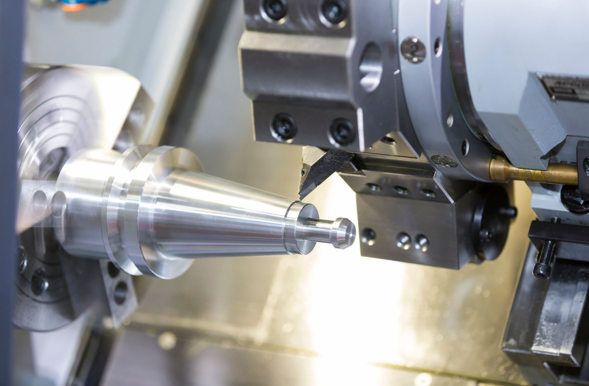 Close-up of CNC machine cutting a white metal piece.