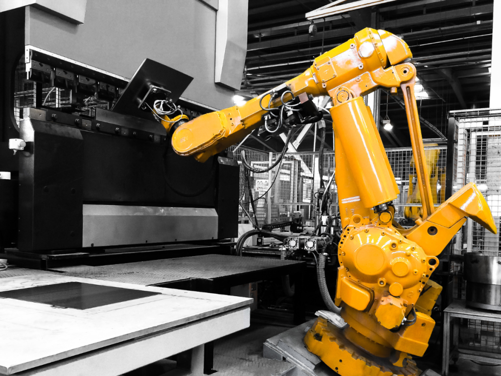 "Industrial robot loads a machine in an automated production system"