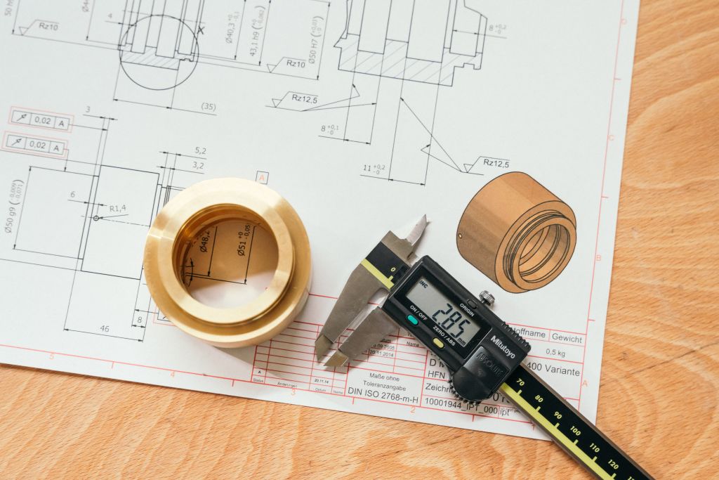 CNC-gefrästes Teil mit digitalen Messschiebern und technischen Zeichnungen für genaue Messungen